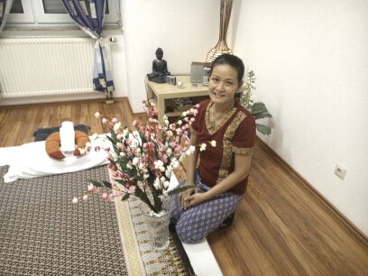 Kitty Kammer kniet vor einem Blumenbuket.