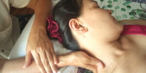 Eine Frau entspannt bei einer Thai Nackenmassage.